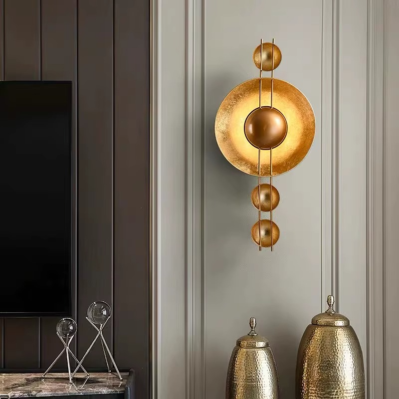 Wandleuchte in Goldoptik mit runder Metallscheibe und 3 Lichtpunkten